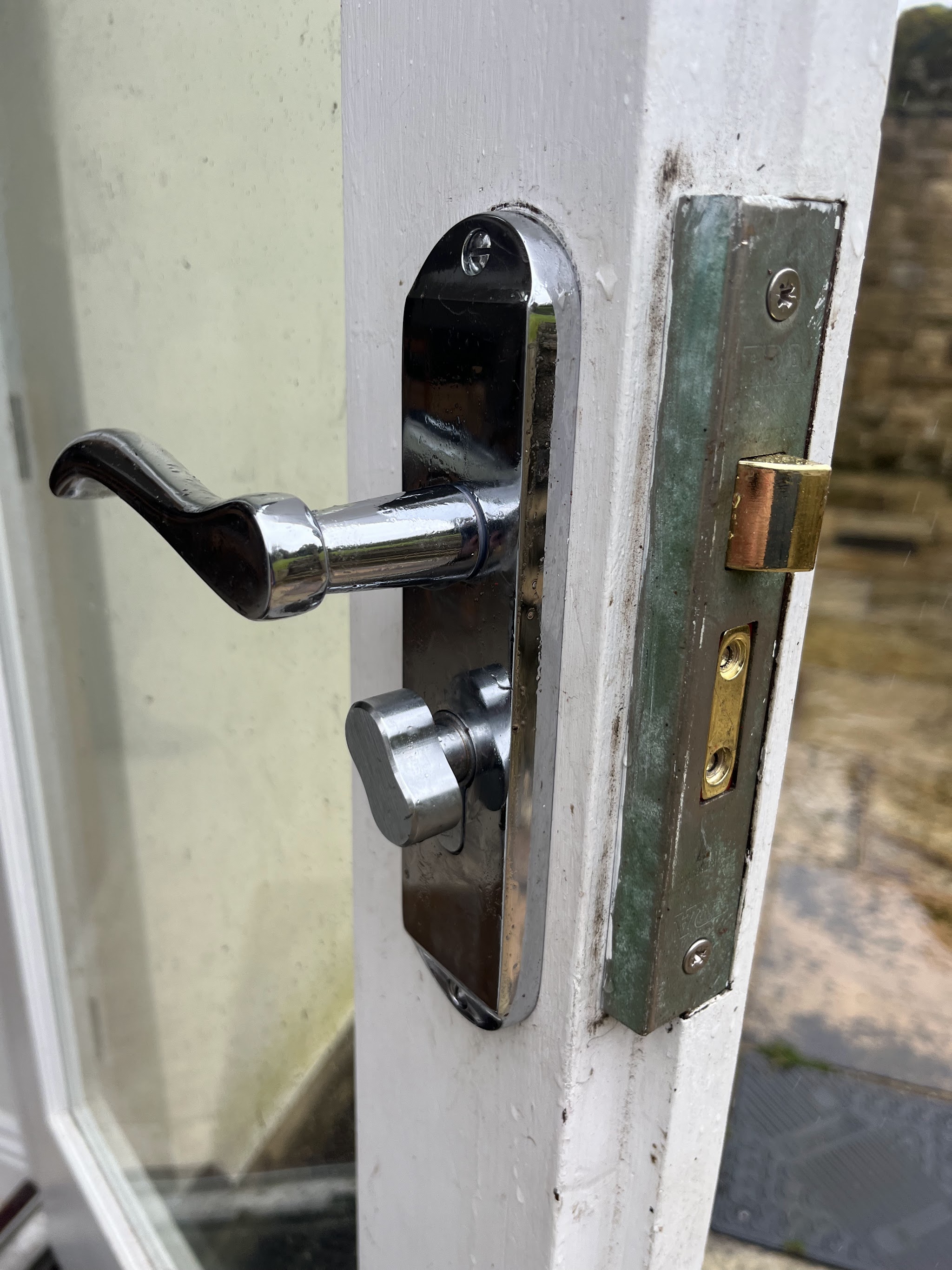 Chrome lever handle and lock fitted to a door